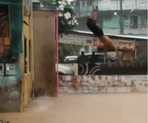Vídeo: homem salta de imóvel em rua alagada e mergulha na lama