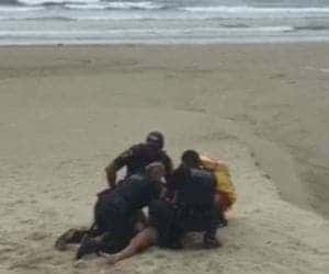 Mulher é imobilizada por guardas após de furar restrição de praia